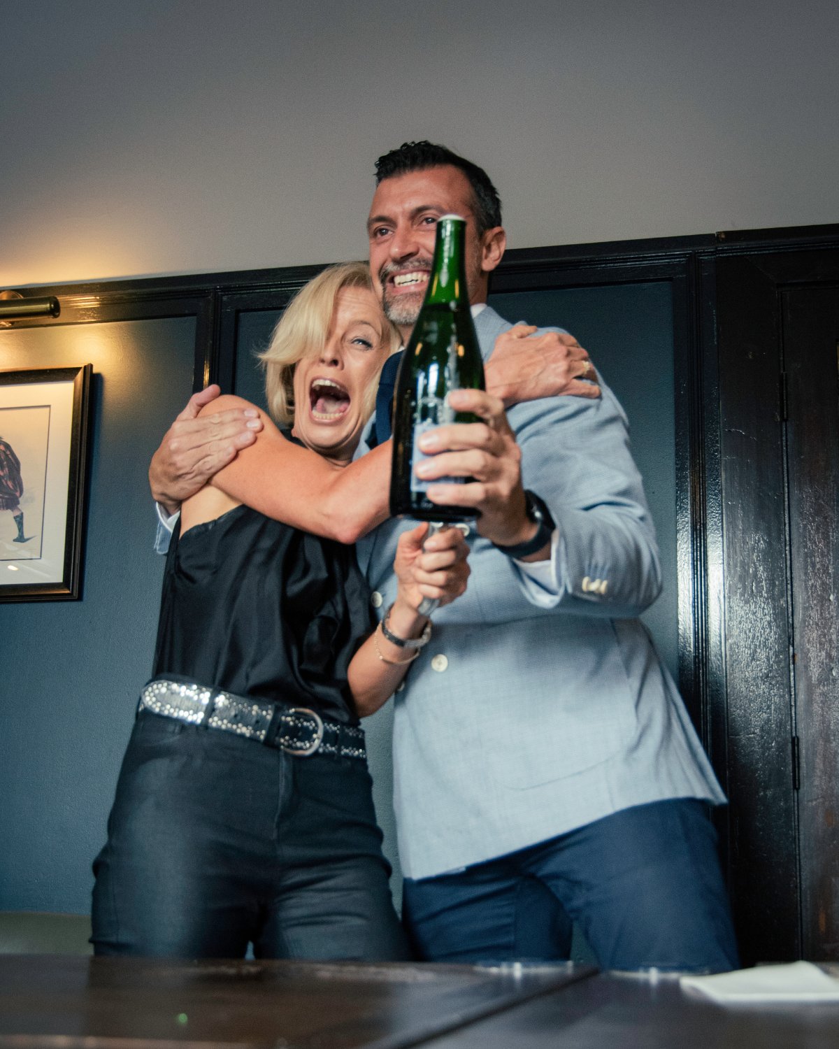 Joanne and Gerardo of DiVino celebrating with a bottle of sparkling wine